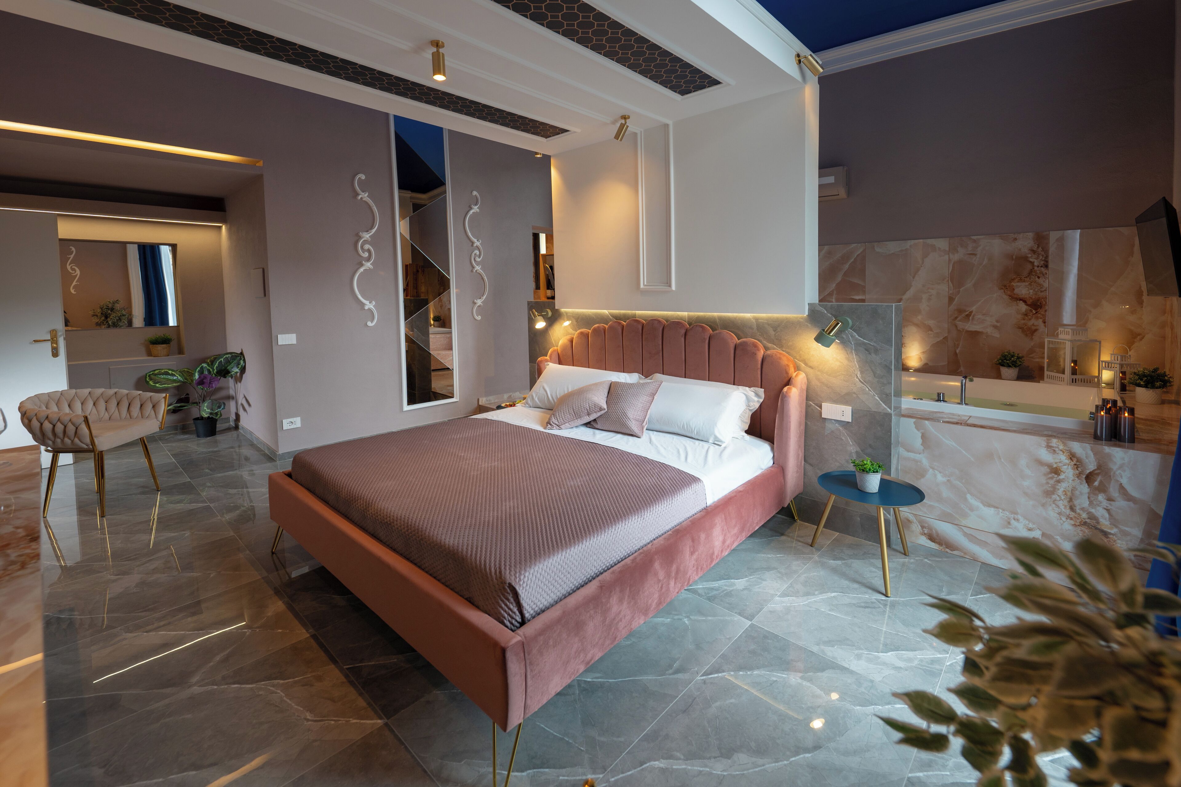 A modern bedroom with a large bed, a small side table, and a chair.