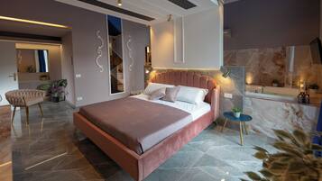 A modern bedroom with a large bed, a small side table, and a chair.