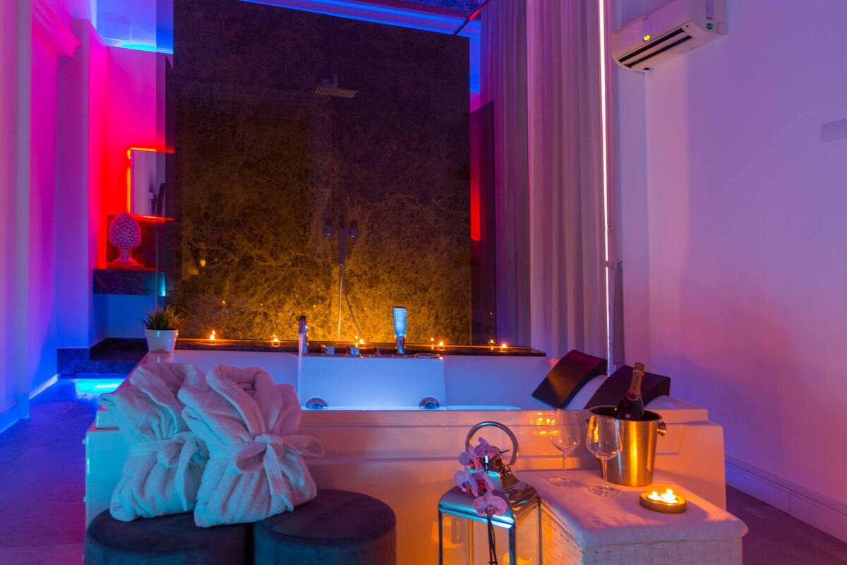A luxurious bathroom with a large mirror, a bathtub, and a decorative ceiling.