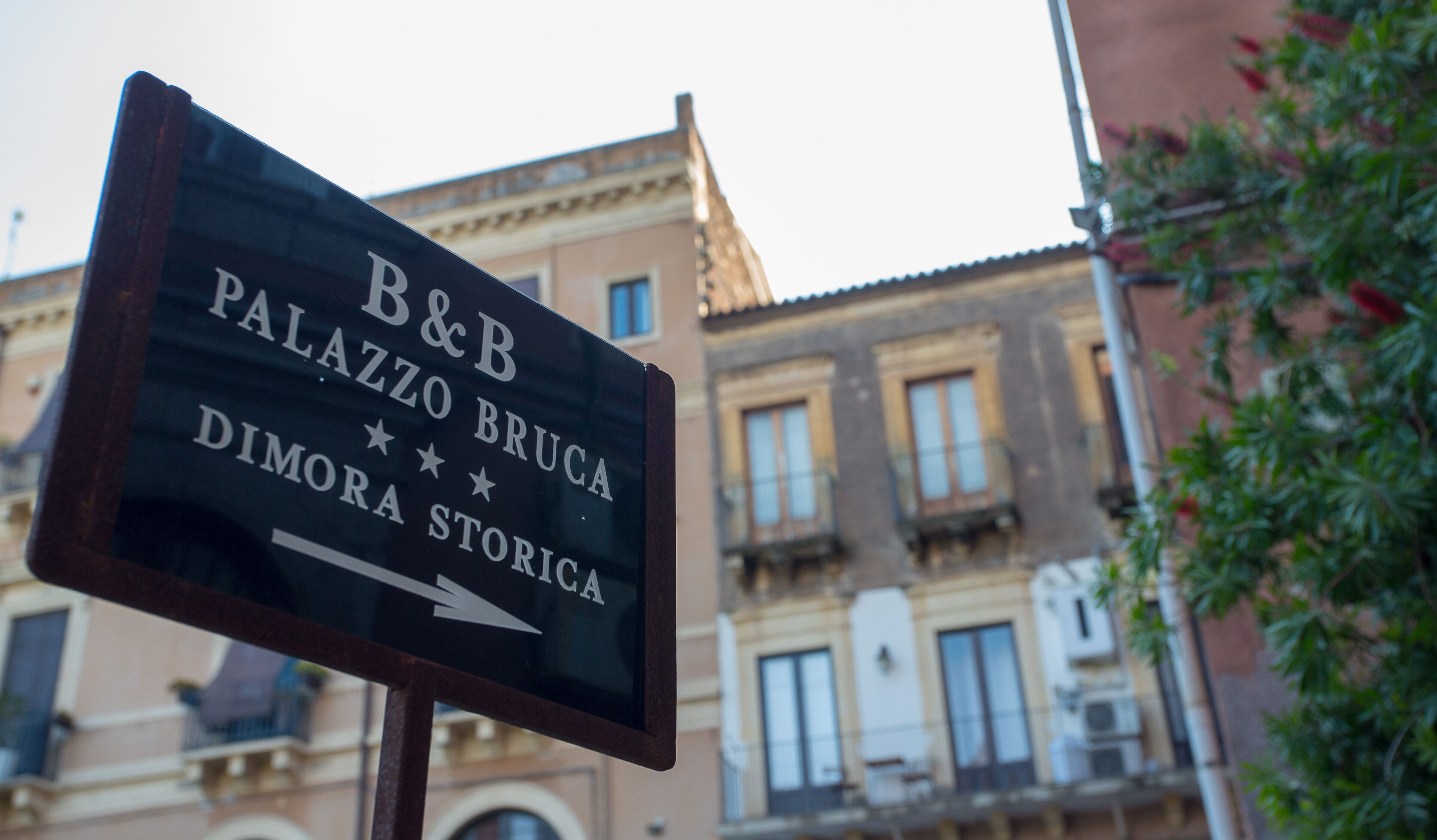 A sign for B&B Palazzo Bruca Dimora Storia with an arrow pointing to the right.