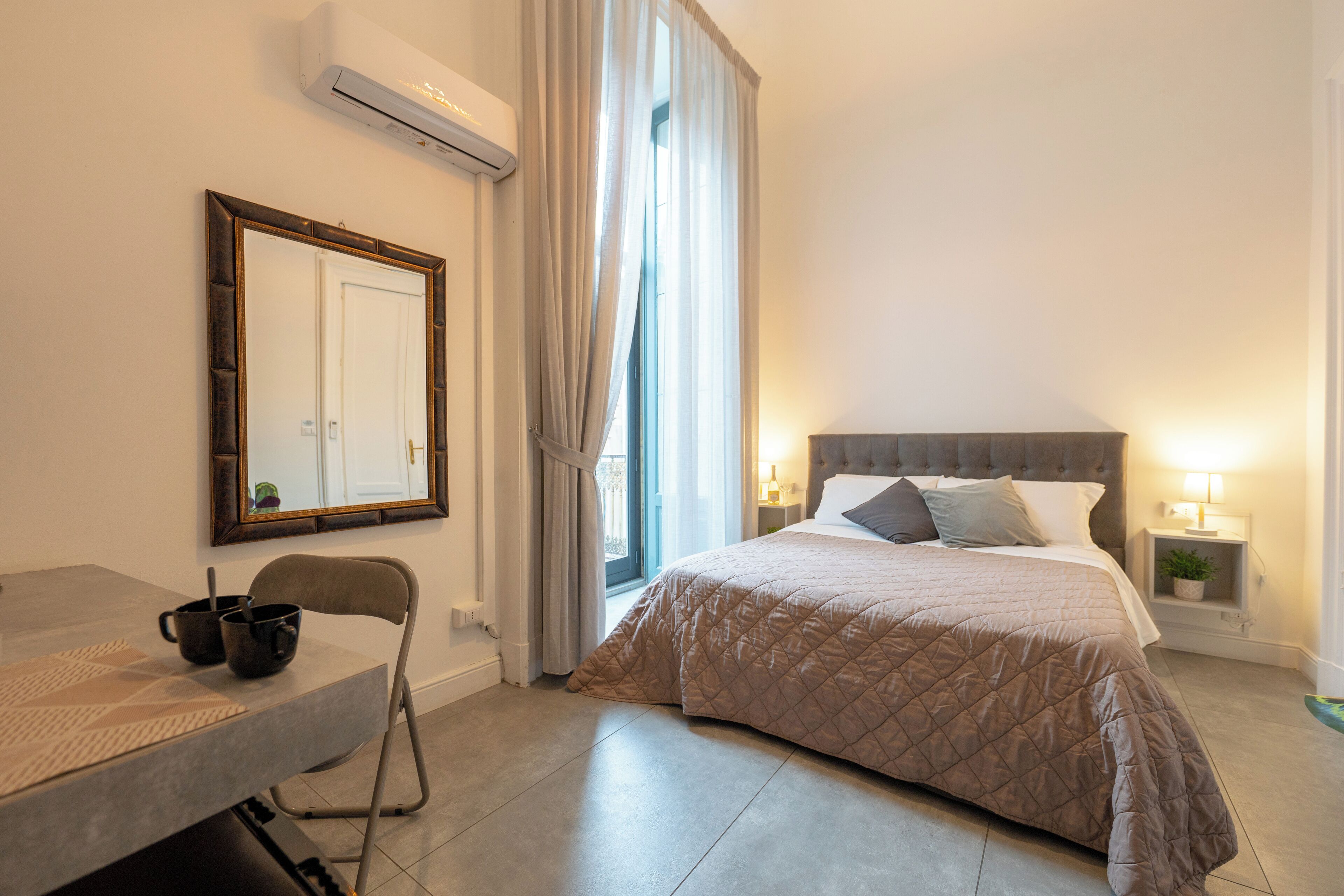Ein Schlafzimmer mit Bett, Nachttischen, einem Sessel und einem Schreibtisch.