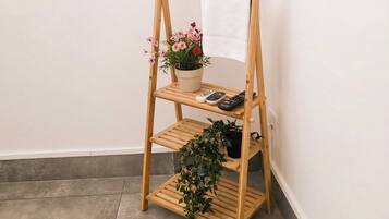 Een houten droogrek met witte handdoeken en potplanten.