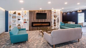 Una sala de estar moderna con chimenea, sofás y televisor.