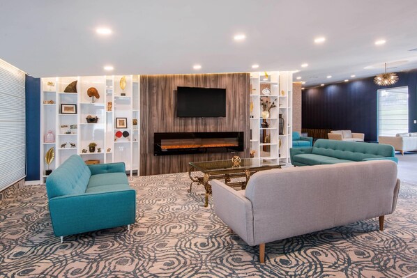 A modern living room with a fireplace, sofas, and a TV. - Quality Inn & Conference Centre (Orillia)