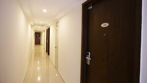 A hotel corridor with a wooden door labeled "104" and a digital lock. - Hotel Westree (Kuala Lumpur)