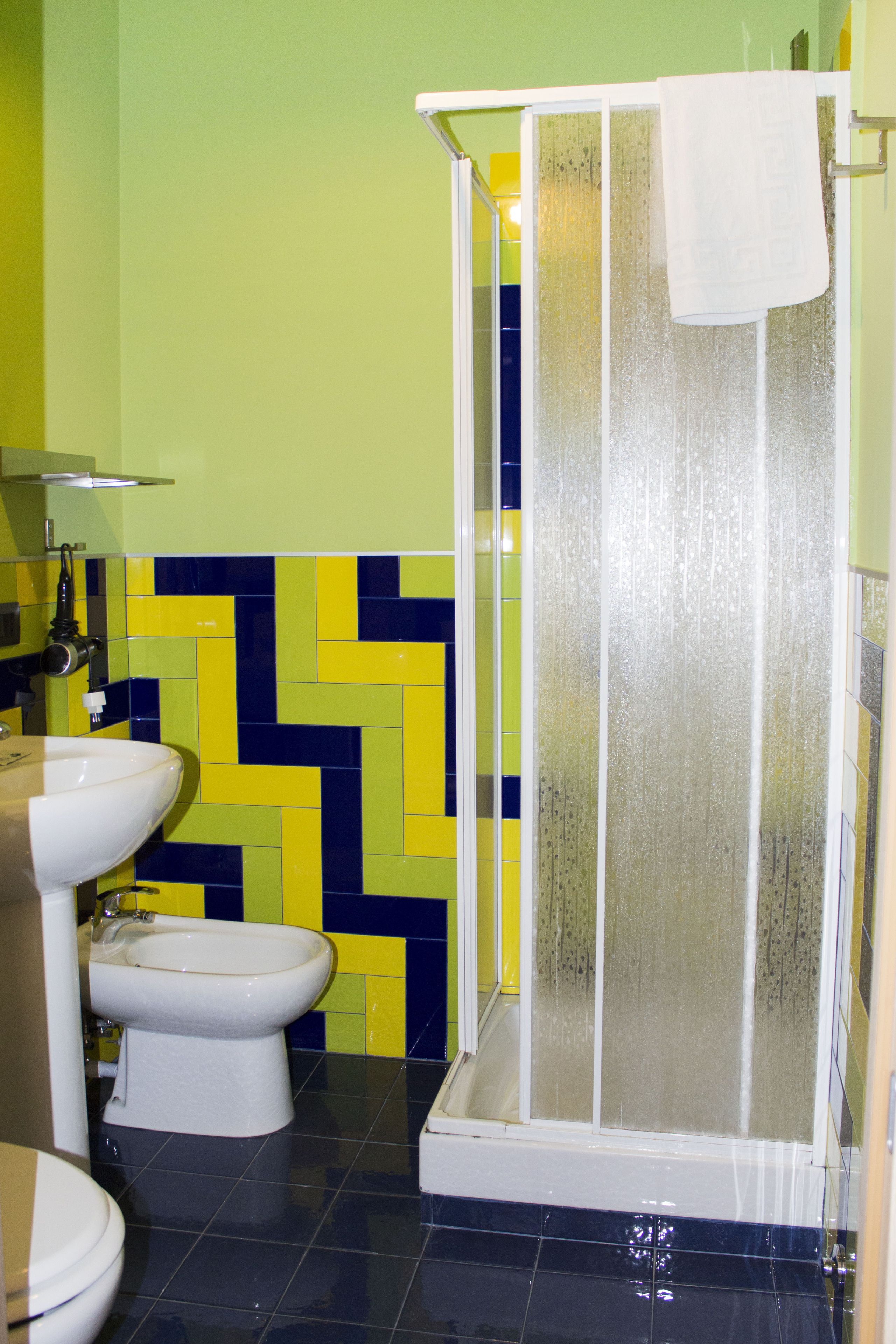 A bathroom with a shower, a sink, and a toilet.