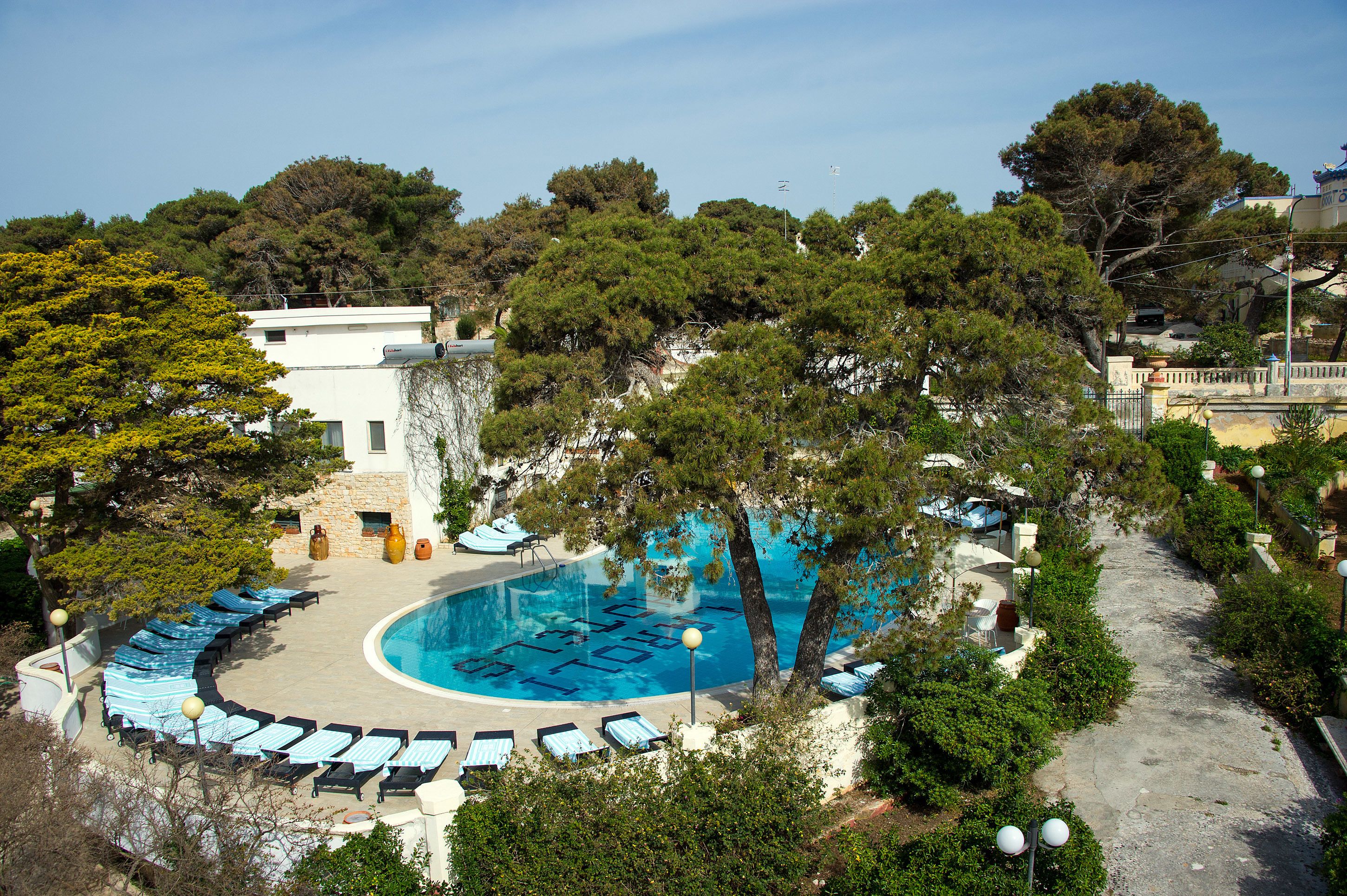 Una piscina amb gandules i un edifici de pedra.