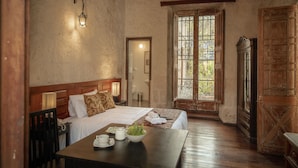 Une chambre avec un lit, une table de chevet, une lampe et une fenêtre donnant sur un beau paysage.