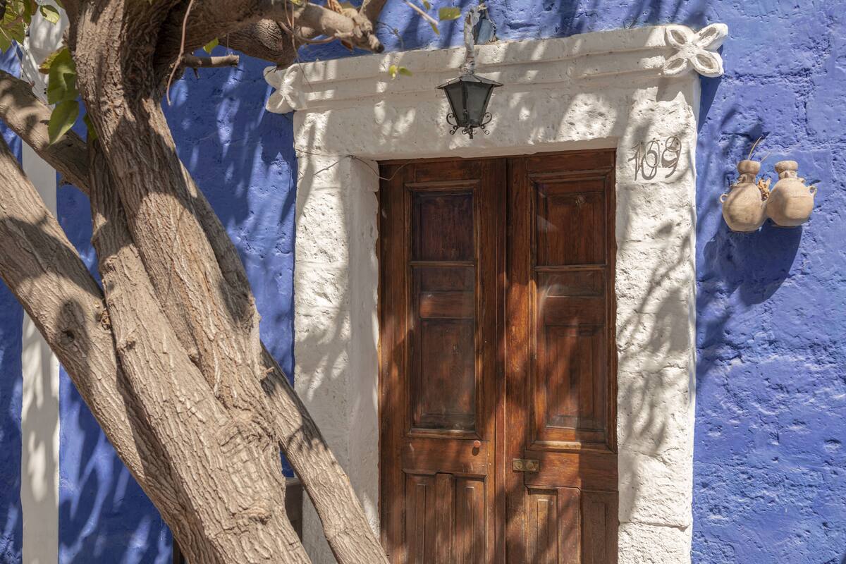 A wooden door with a white wall and a blue door frame.