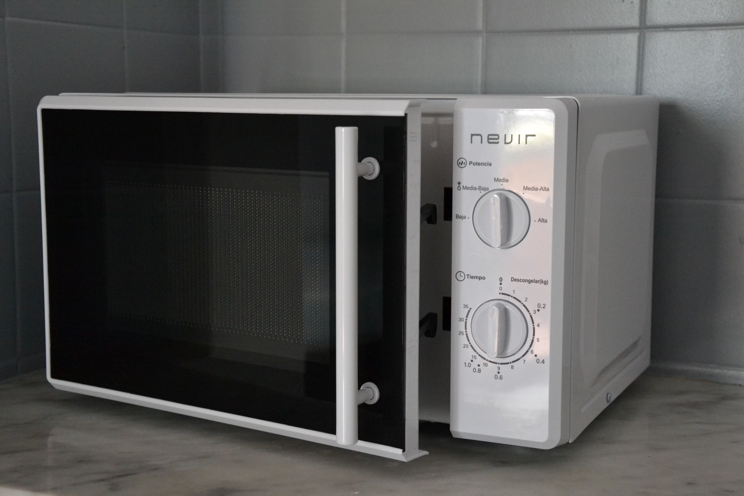 Een compact magnetron met een digitaal display en bedieningsknoppen voor vermogen en tijdinstellingen.