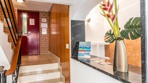A reception area with a marble counter, a red door, and a staircase.
