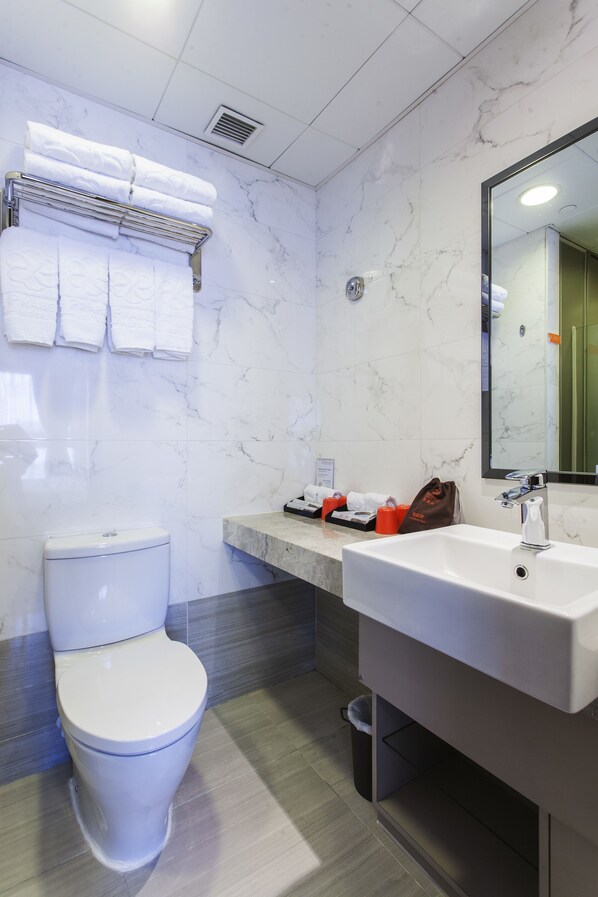 A modern bathroom with a toilet, a sink, and a mirror. - Le Prabelle Hotel (Kowloon)