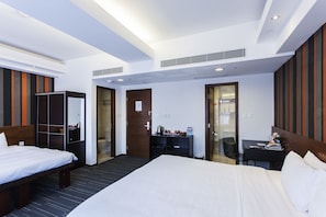 A hotel room with two beds, a desk, a chair, a wardrobe, and a bathroom. - Le Prabelle Hotel (Kowloon)