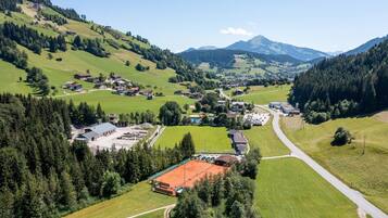 A rural village with houses, a tennis court, and a road.