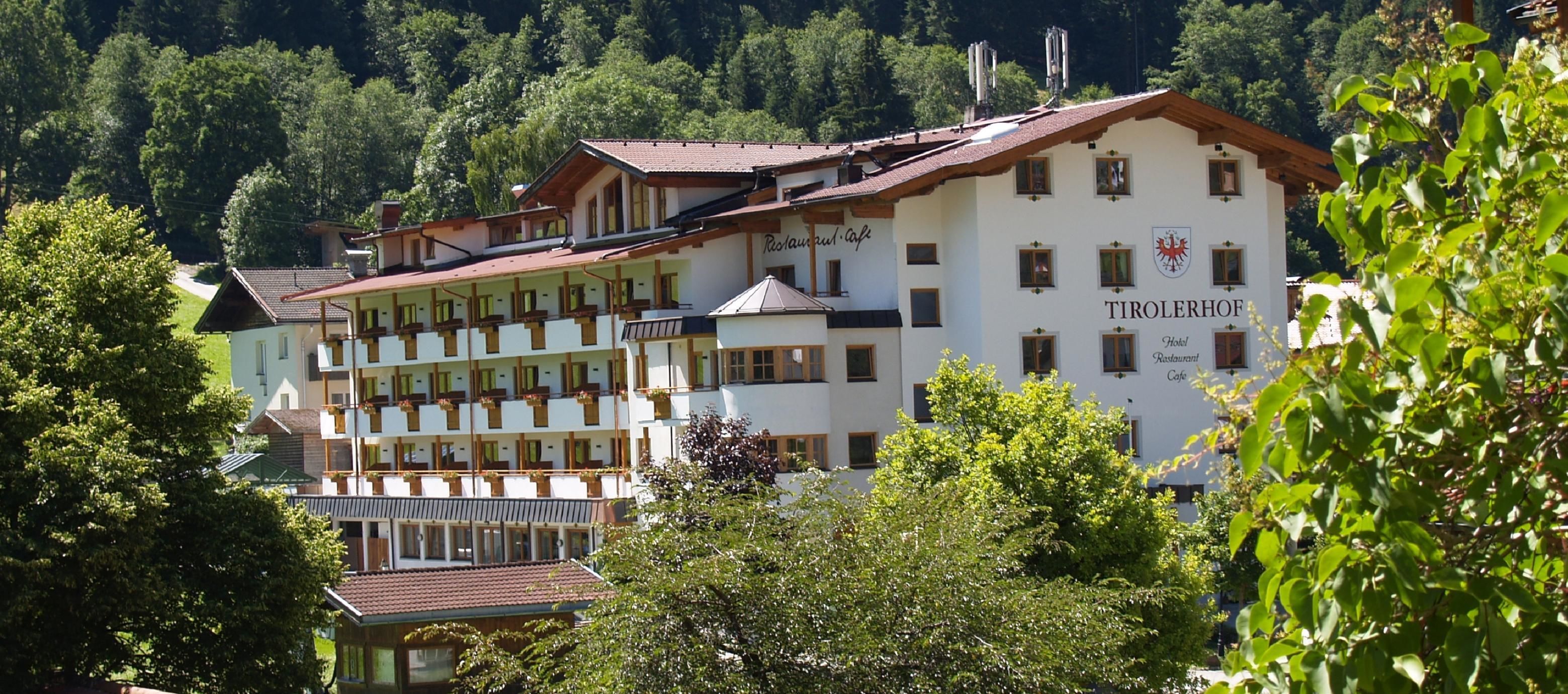A hotel with multiple floors, balconies, and a restaurant cafe.