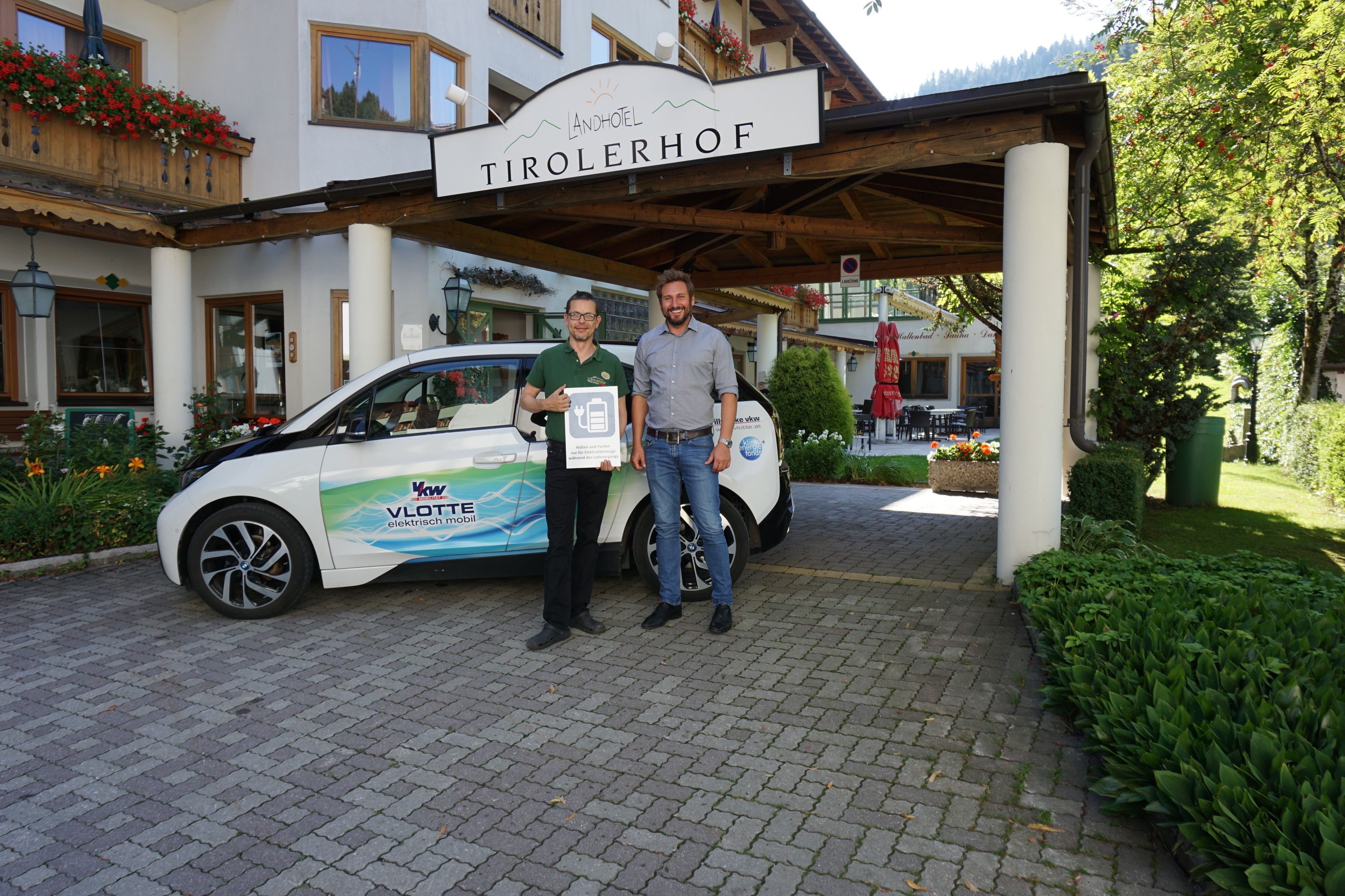 A building with a sign reading "TIROLERHOF" and a white car parked in front.