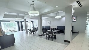 A spacious hotel lobby with high ceilings, modern chandeliers, and a central seating area with tables and chairs. - Holiday Inn Express & Suites Bonham by IHG (Bonham)
