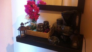 Une étagère avec un vase de fleurs, une lanterne et divers récipients.