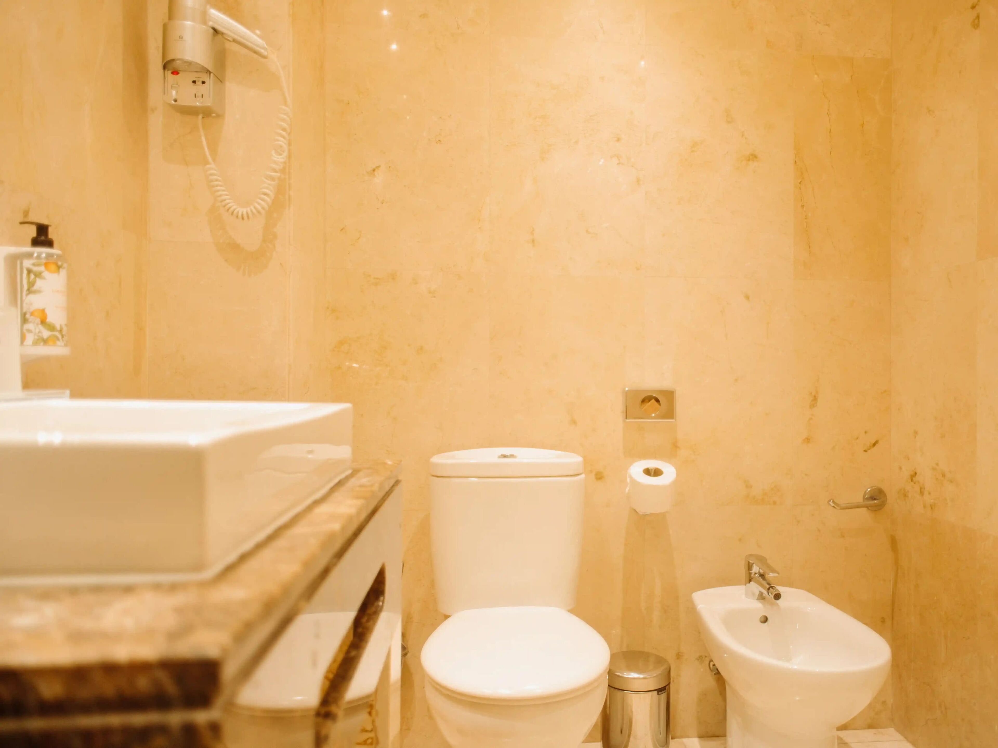 Un baño con inodoro, bidé y lavamanos.