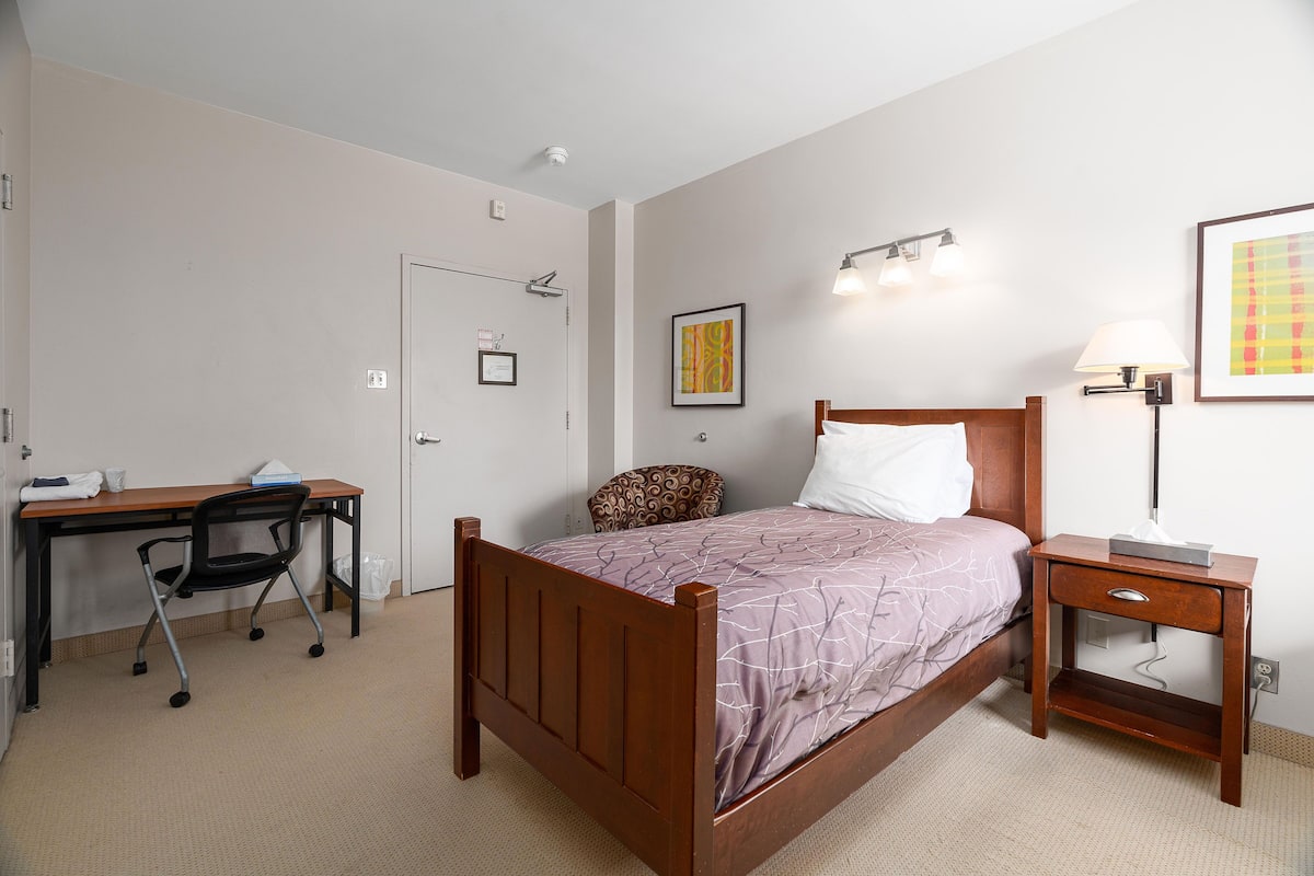 Une chambre à coucher avec un lit en bois, un bureau et une chaise.
