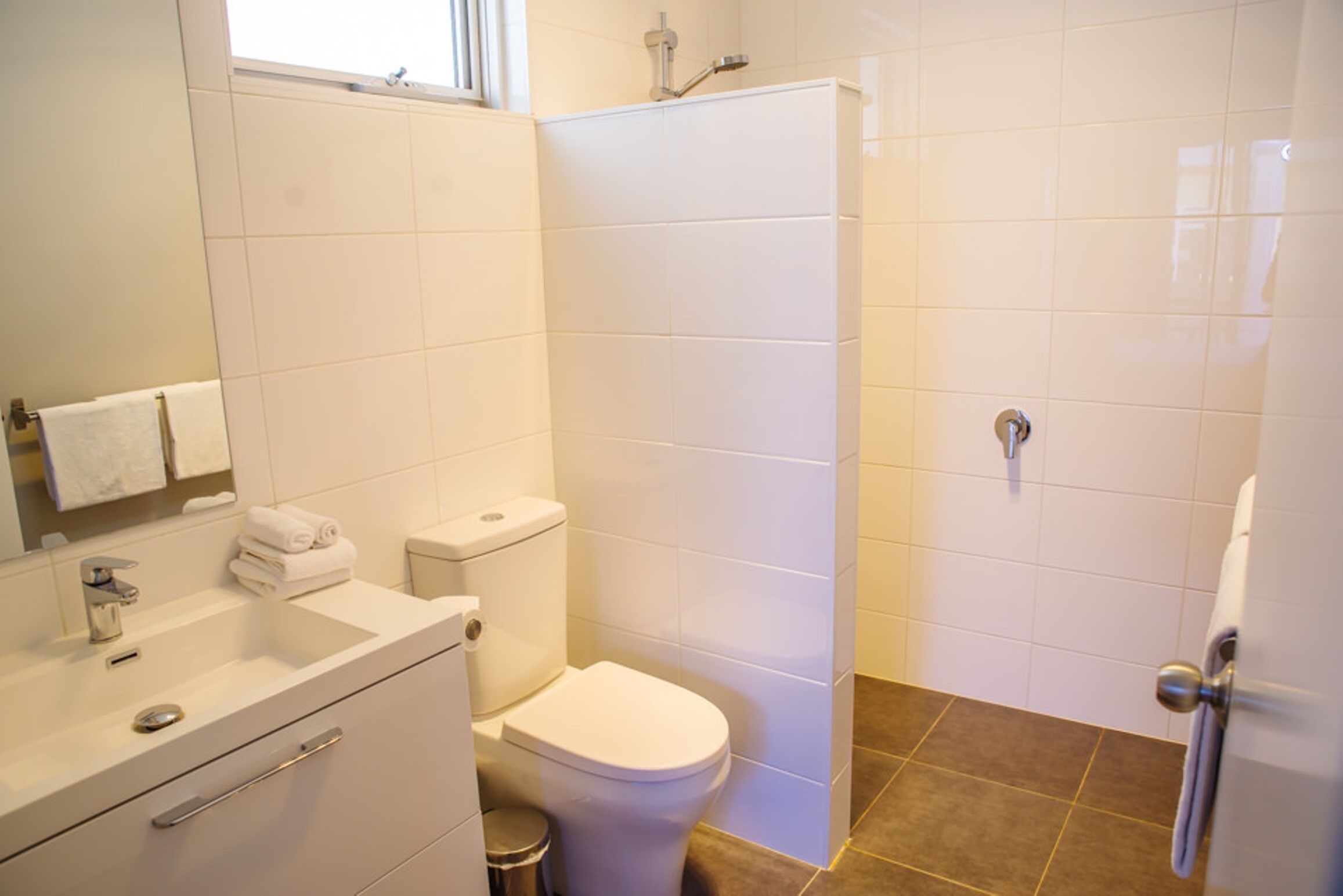 A bathroom with a toilet, sink, and shower.
