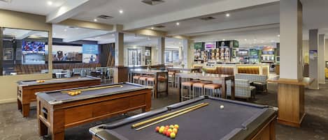 A pool table with balls, a bar area, and seating.