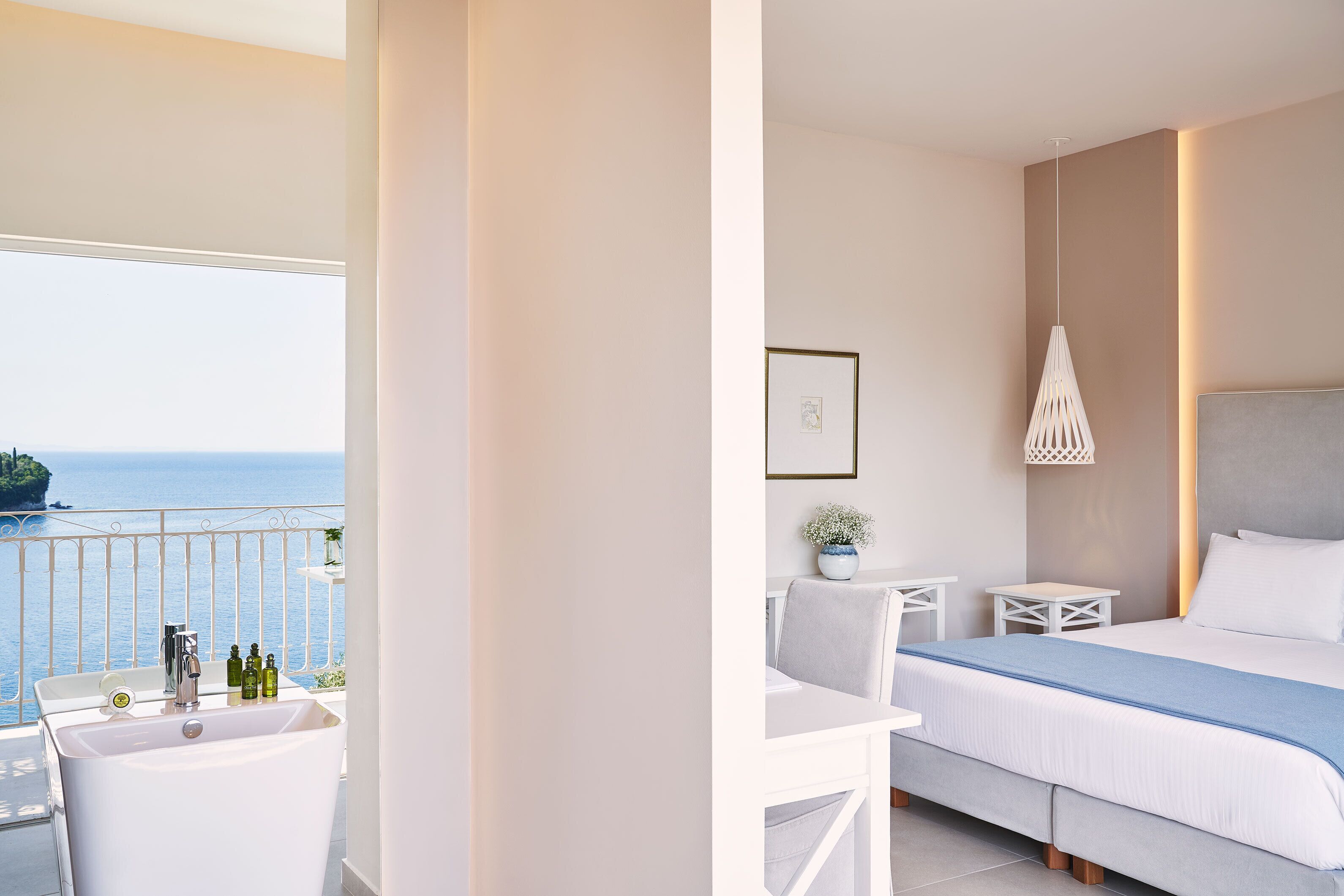 Una habitación de hotel moderna con balcón, cama, escritorio y baño.