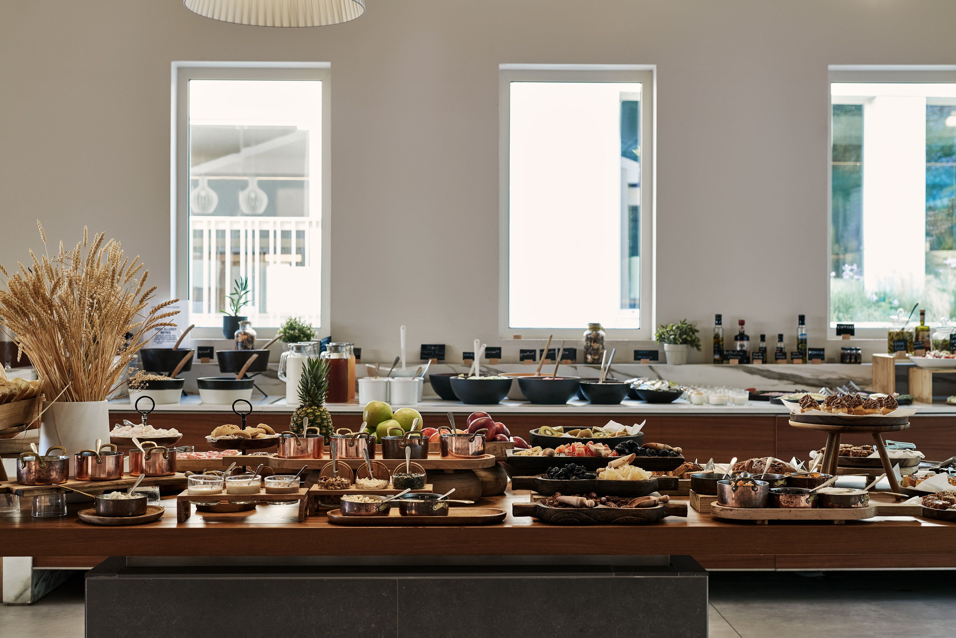 A buffet setup with various food items and utensils.