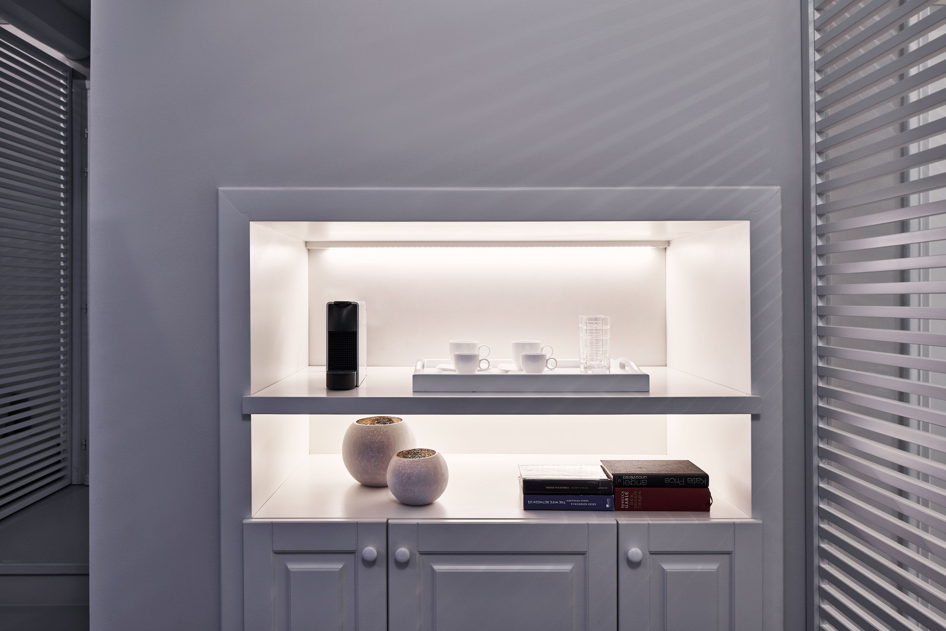 A white shelving unit with two levels, each containing various items.