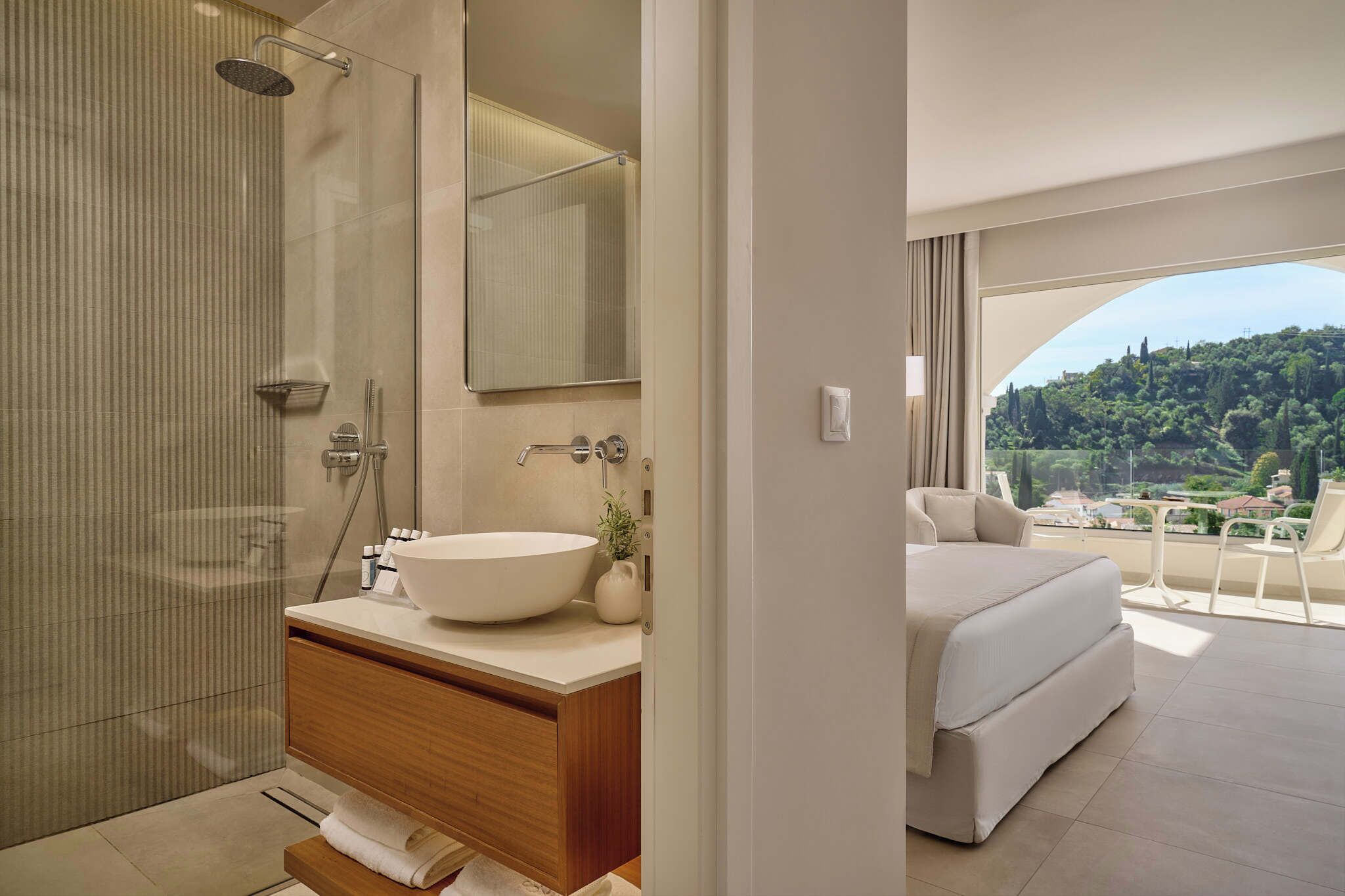 Un baño moderno con un espejo grande, cabina de ducha y tocador con un lavabo espacioso.