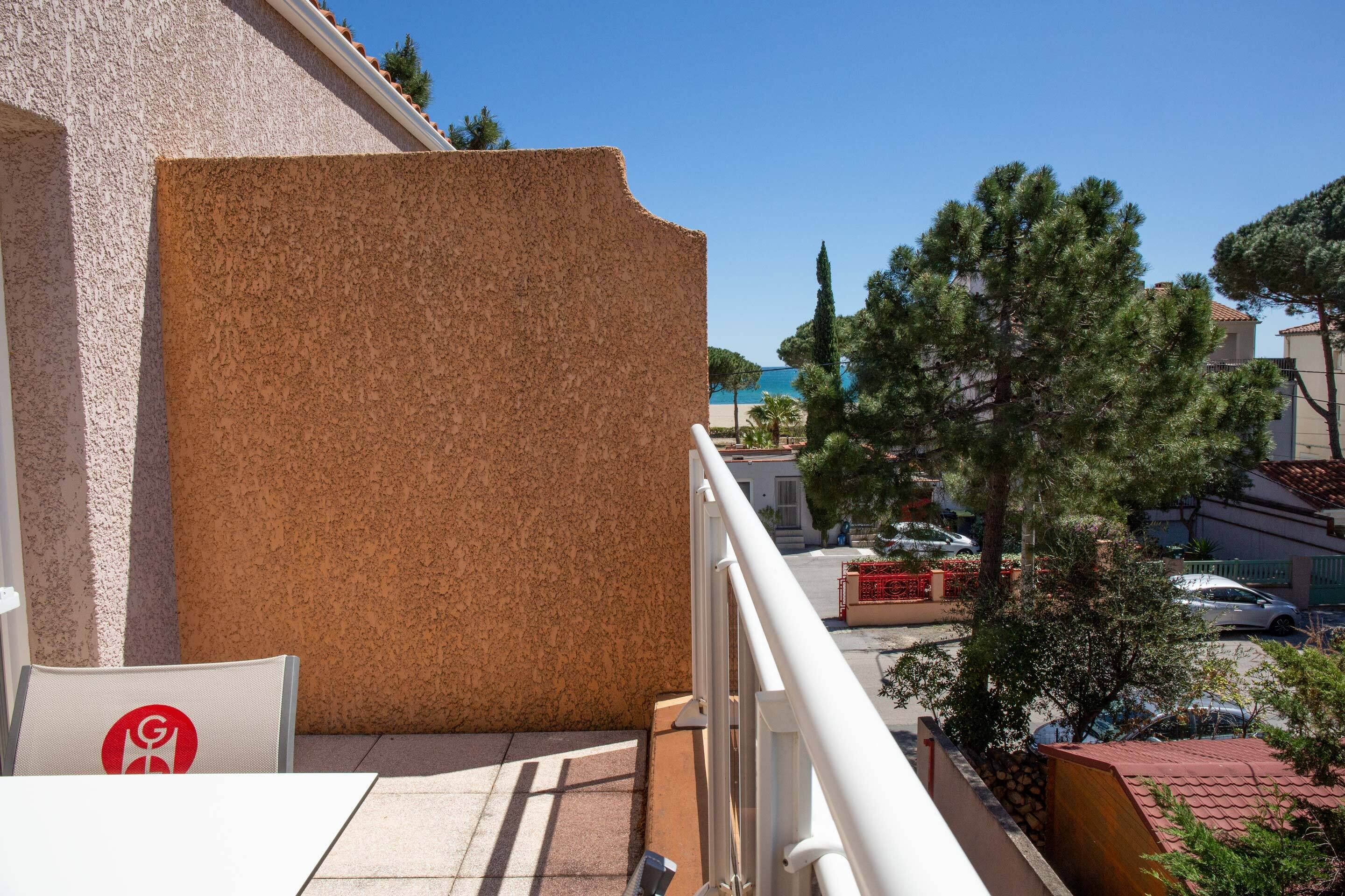 Ein Balkon mit Blick auf Strand und Gebäude.