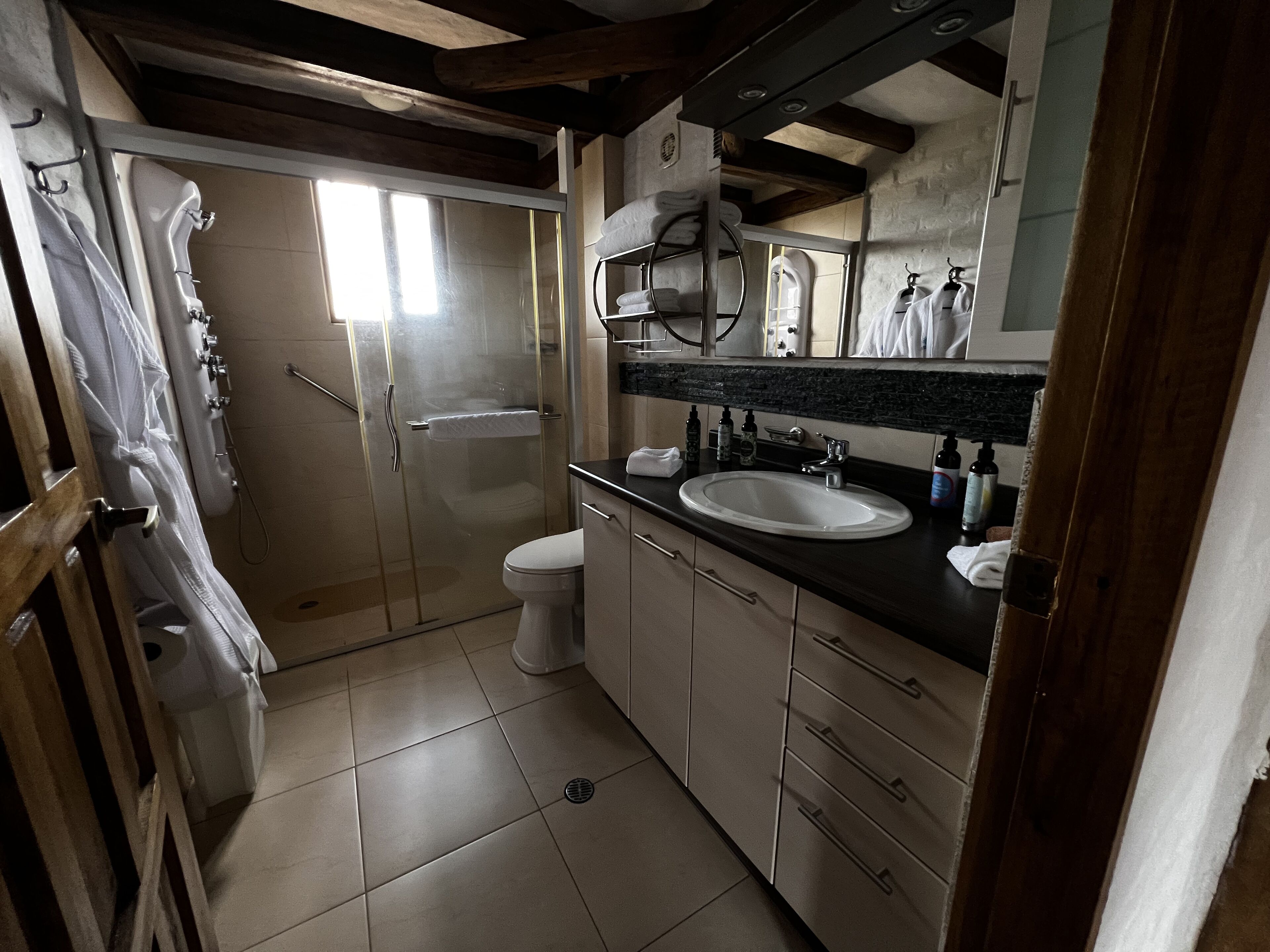 Un baño con ducha, inodoro, lavabo y armarios.