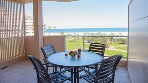 A balcony with a table, chairs, and a view of the beach. - Résidence les Flamants Roses (Canet-en-Roussillon)