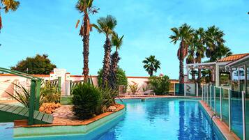 Una piscina al aire libre de temporada, tumbonas