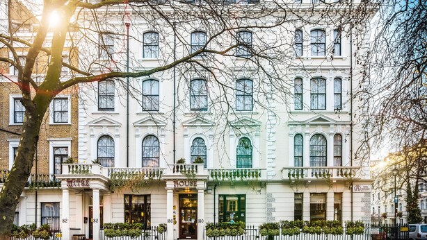 Un edificio histórico con una fachada clásica, numerosas ventanas y una entrada destacada.