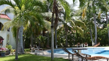 Alberca al aire libre y camastros