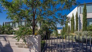 A gated entrance to a luxury resort with a clear sky and lush greenery.