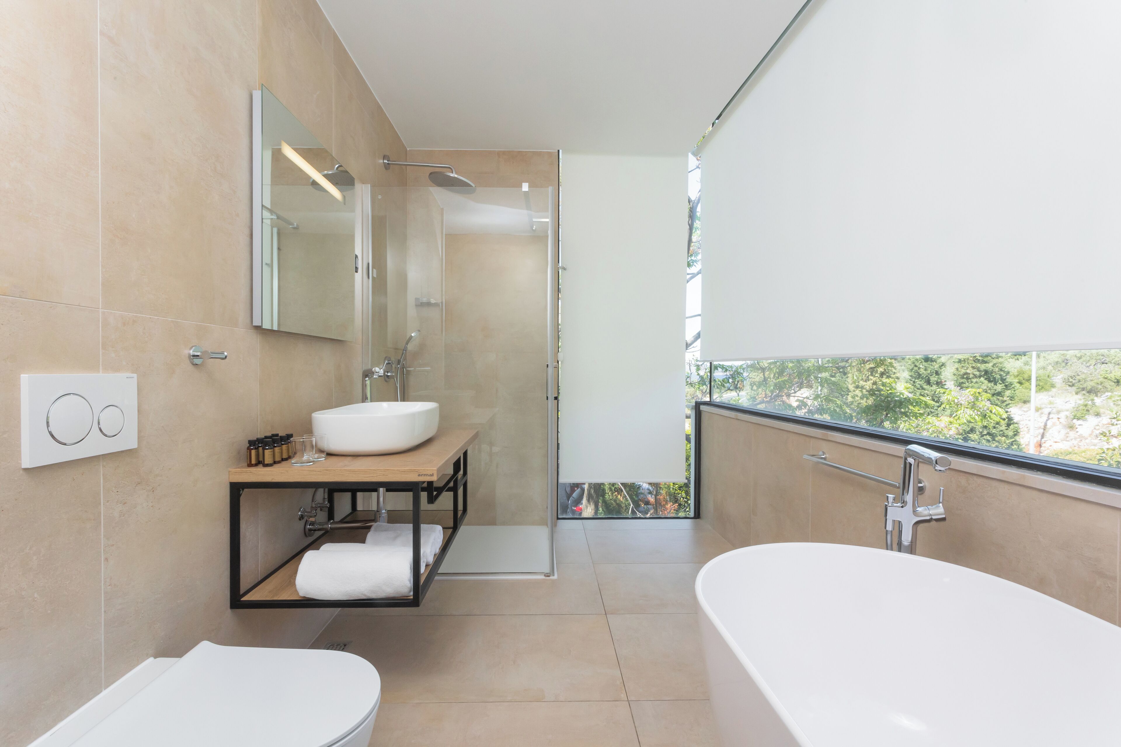 Un baño moderno con una bañera grande, un lavamanos y una ducha.
