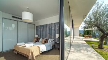 Un dormitorio moderno con una cama grande, una mesita de noche y vistas al exterior.