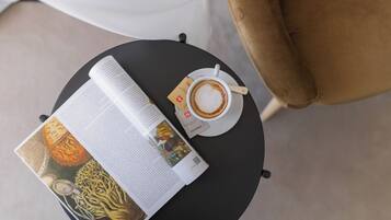Un libro, una taza de café y un menú sobre una mesa redonda.