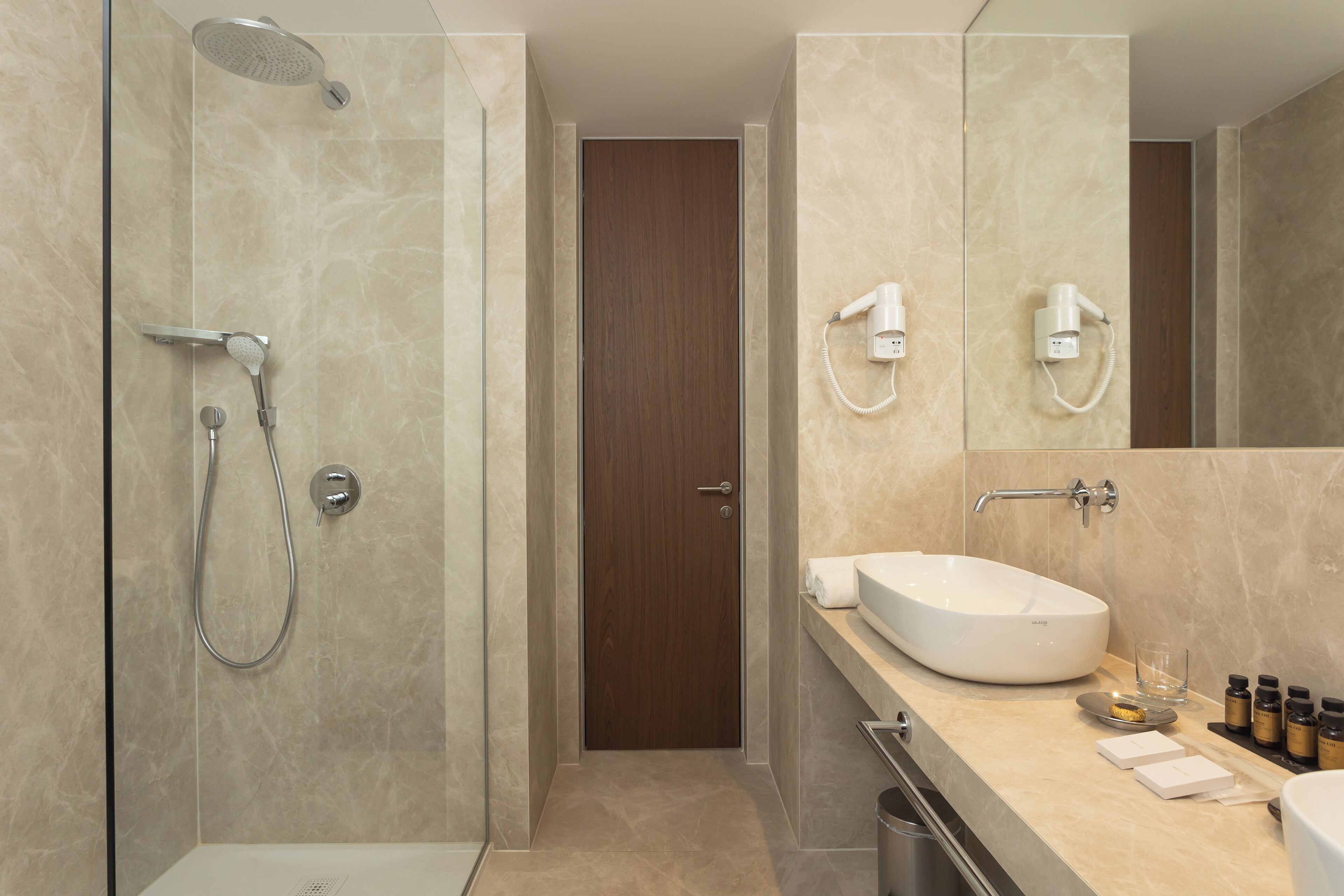 A modern bathroom with a shower, a sink, and a mirror.