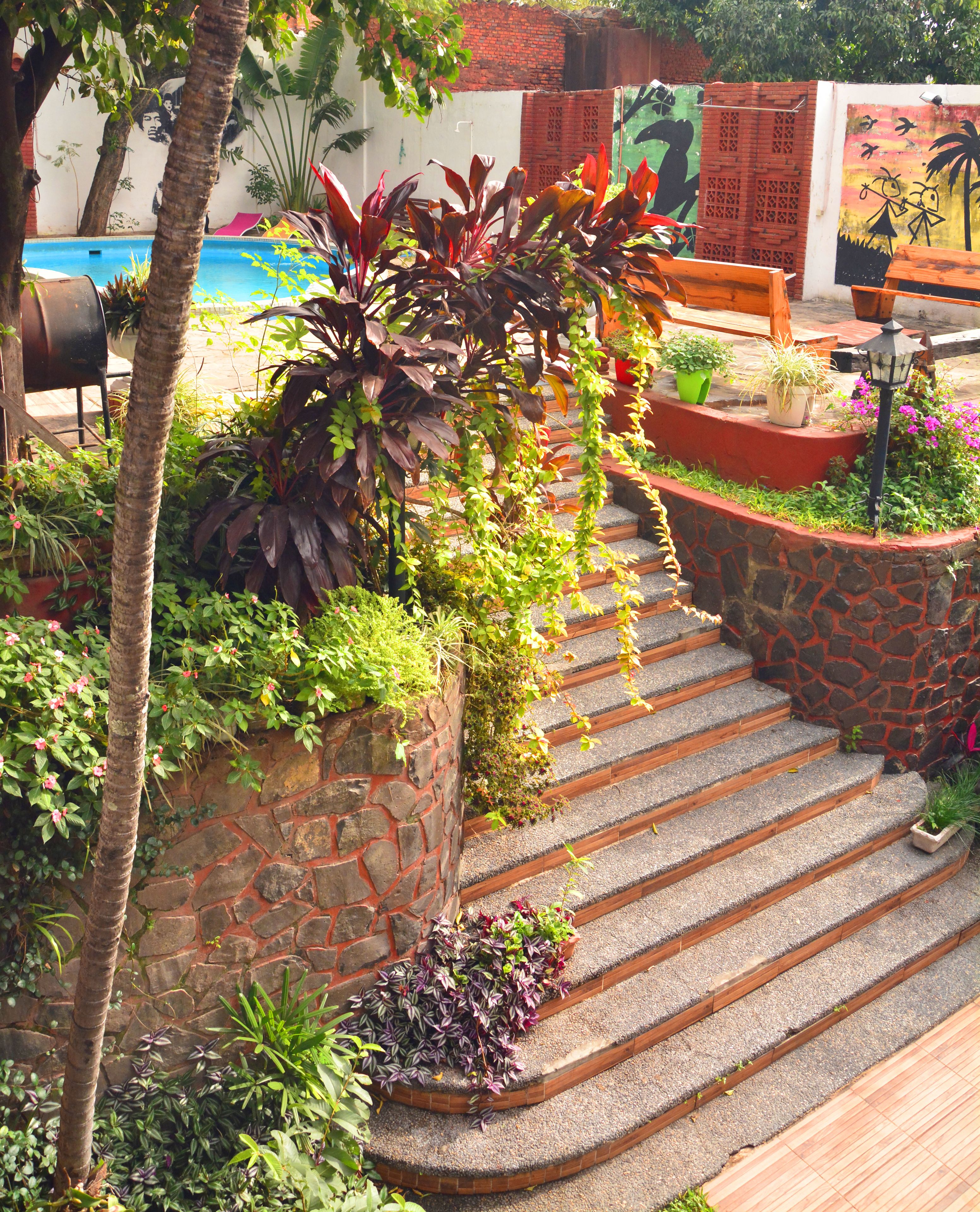 A stone staircase surrounded by lush greenery and potted plants.