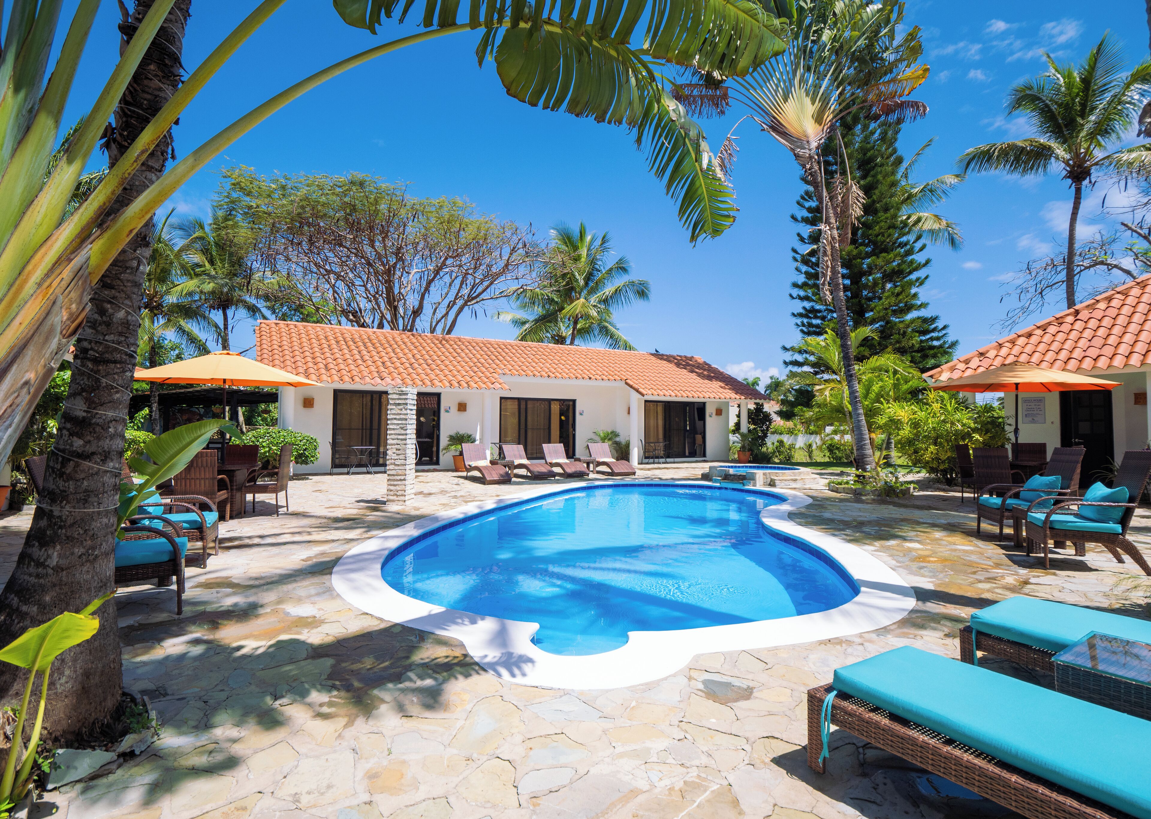 Una piscina al aire libre, sombrillas, tumbonas