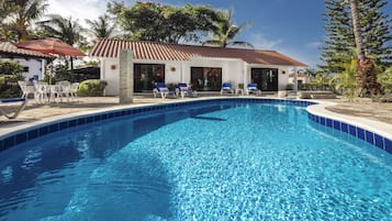 Una piscina al aire libre, sombrillas, tumbonas