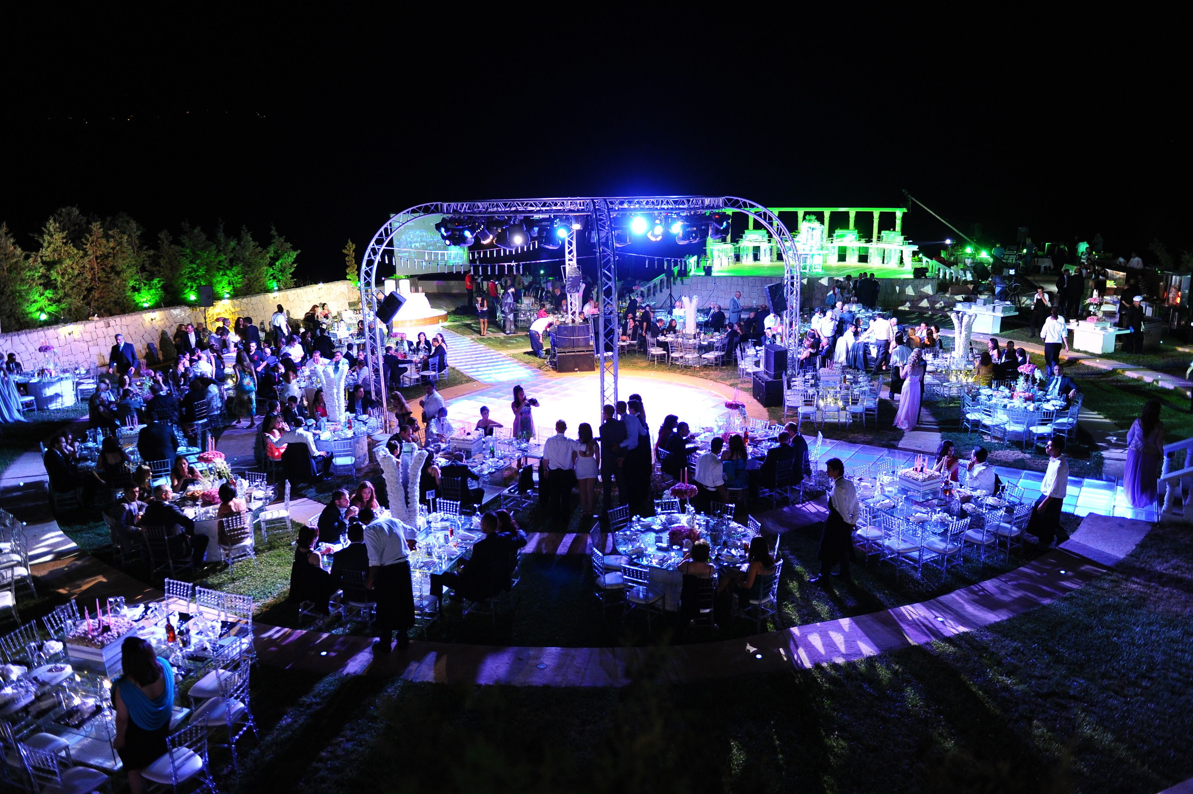 An outdoor event with multiple tables and chairs arranged for guests.