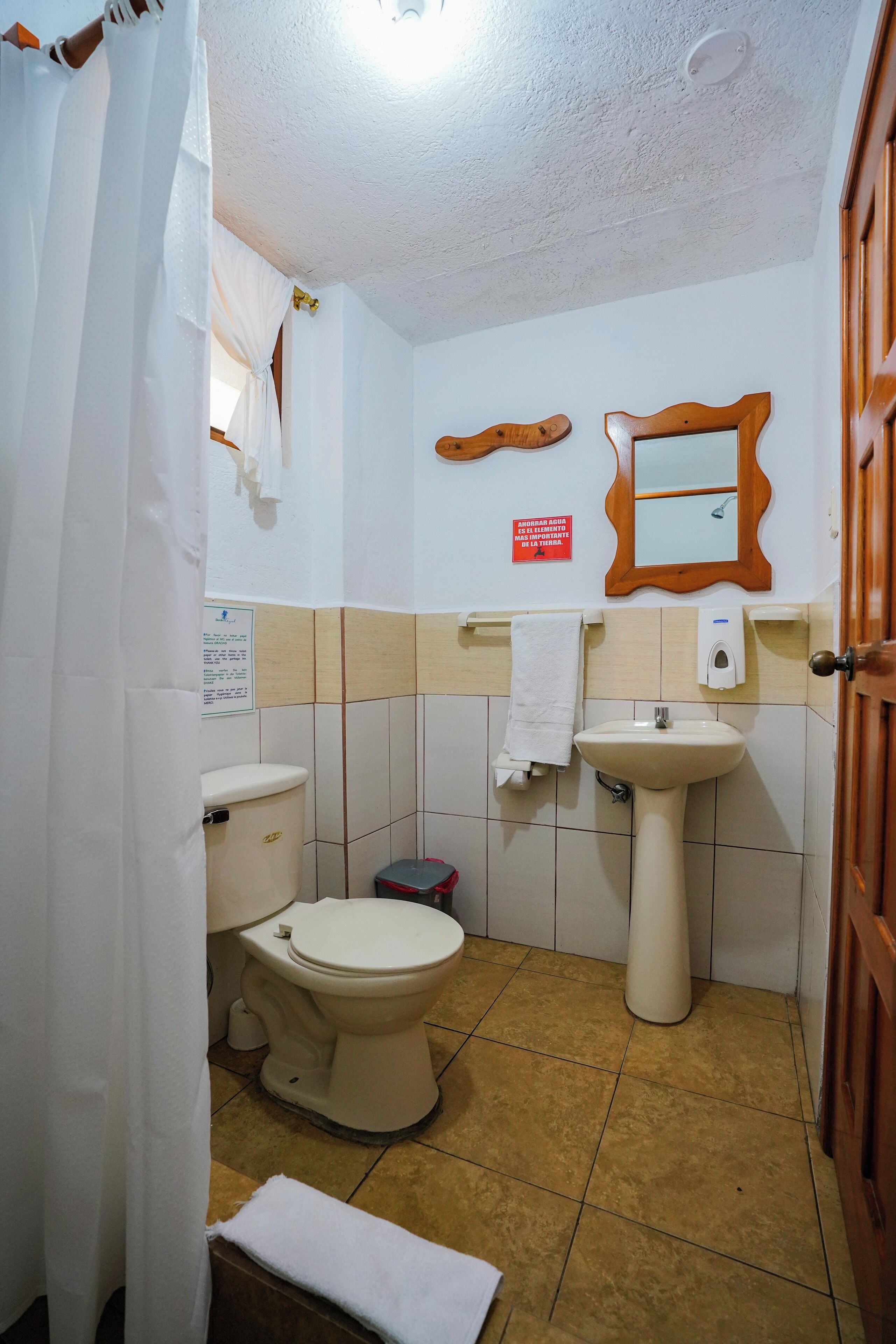 Une petite salle de bain avec des toilettes, un lavabo et un miroir.