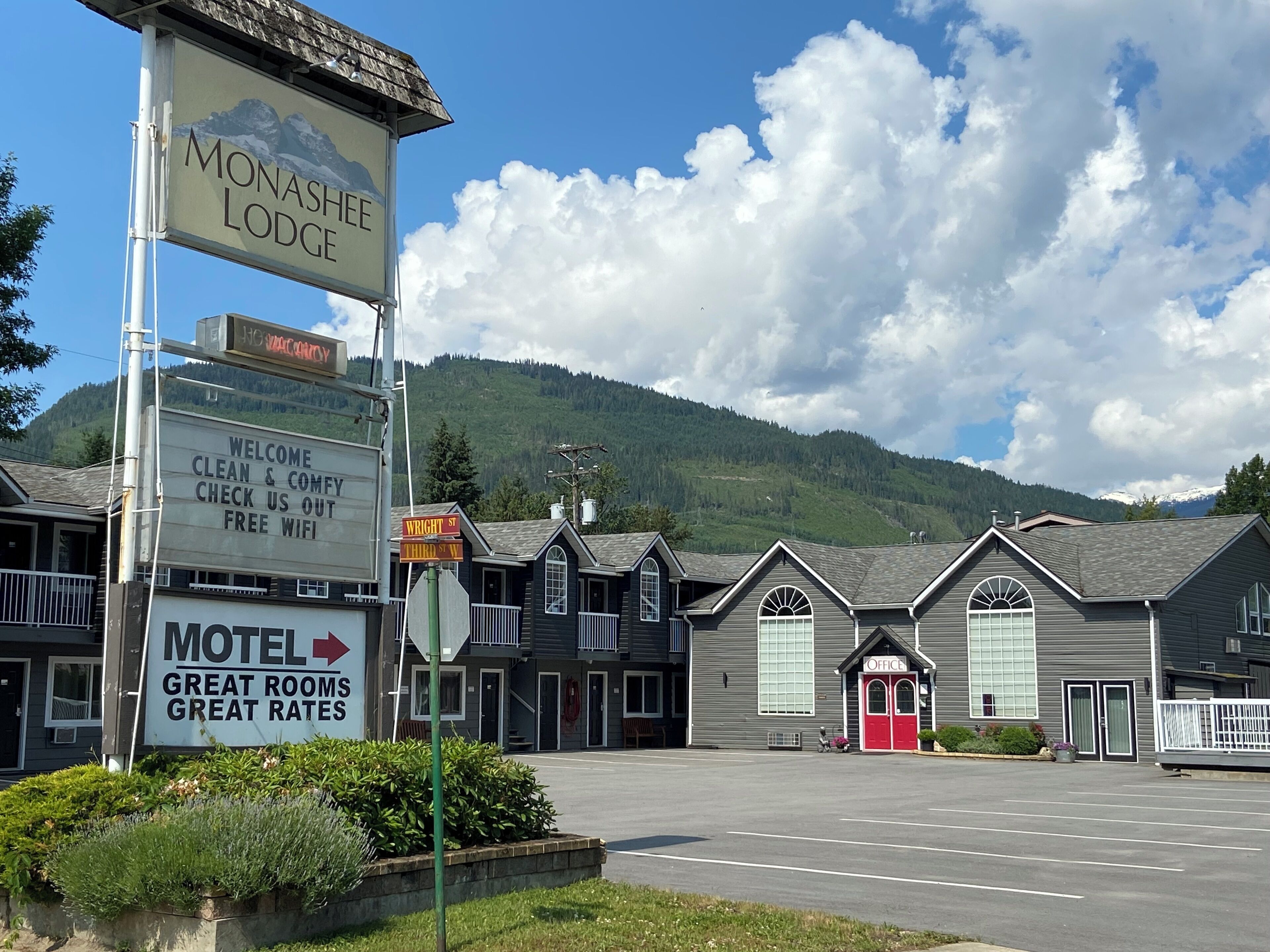 A motel named Monashee Lodge with a signboard advertising great rooms and rates.