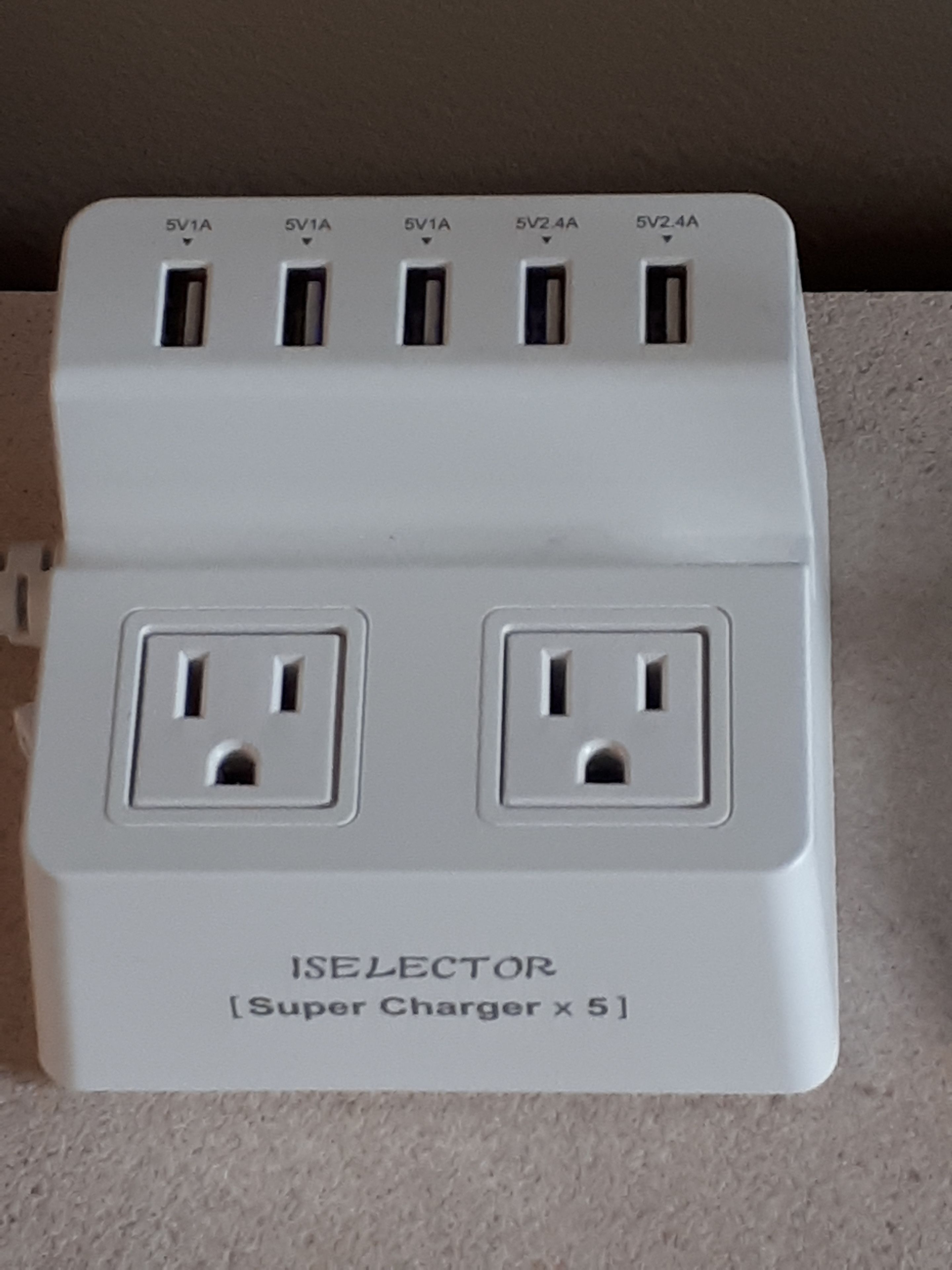 A white power strip with multiple outlets and USB ports labeled 5V1A and 5V2.4A.