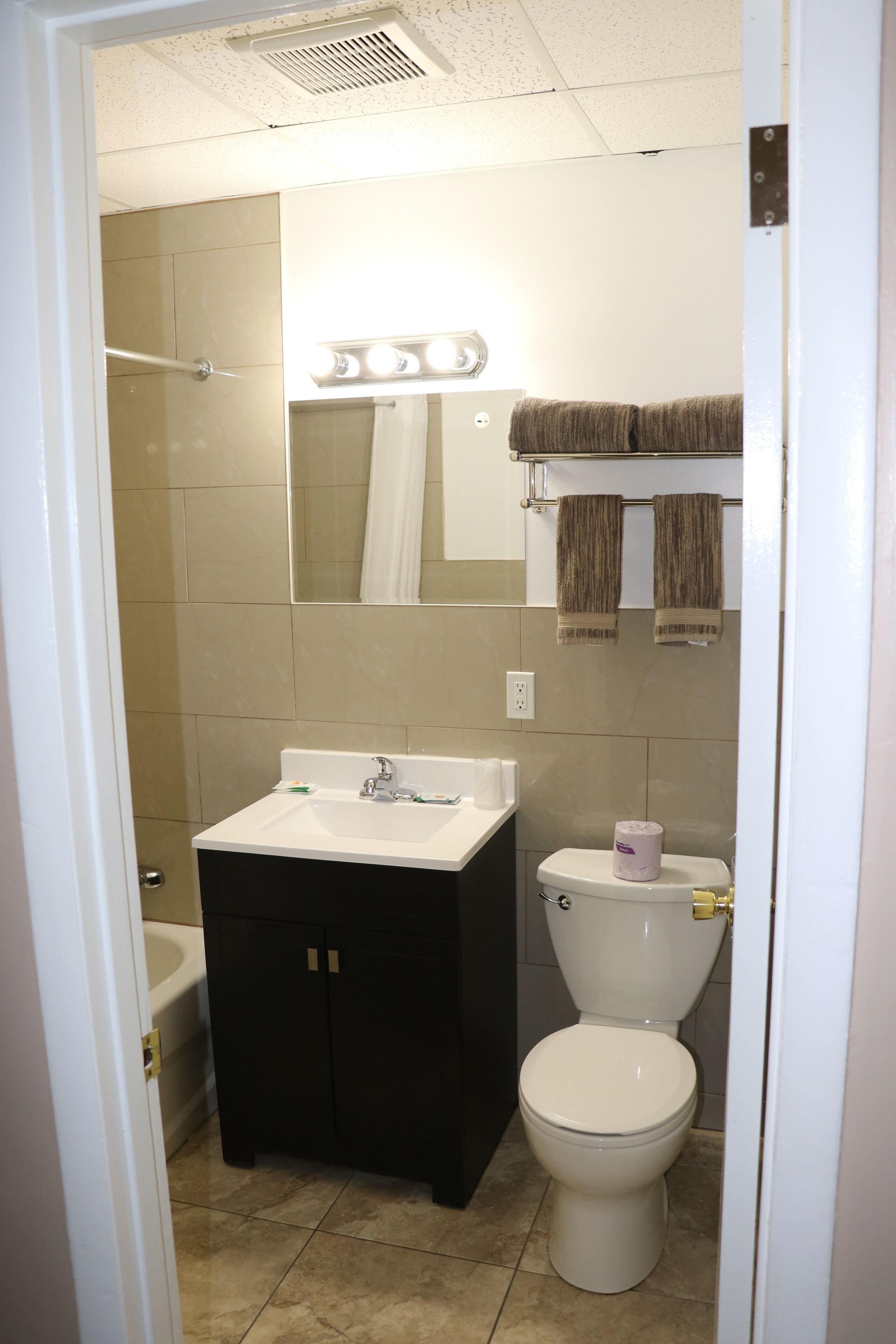 Un baño con lavabo, espejo e inodoro.
