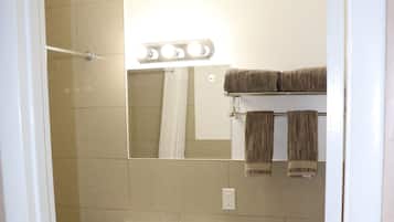 Un baño con lavabo, espejo e inodoro.